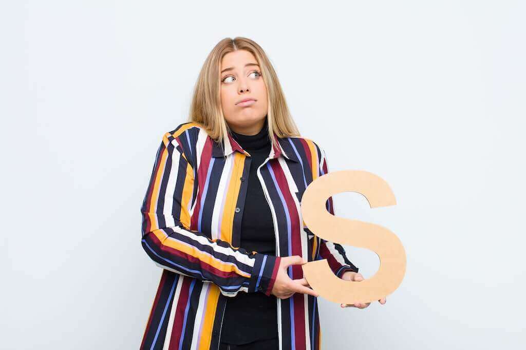 Puzzled woman holding a letter S and thinking about webinar cost